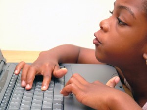 child at laptop - poor posture as chair too low